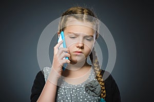 Astonished cute girl with cell phone. isolated on gray