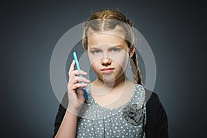 Astonished cute girl with cell phone. isolated on gray