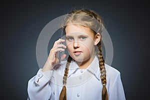 Astonished cute girl with cell phone. isolated on gray