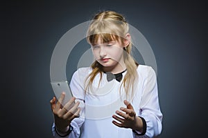 Astonished cute girl with cell phone. isolated on gray