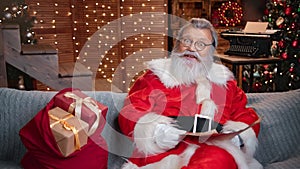 Astonished male Santa Claus grumble wish list at illuminated garland. Shot with RED camera in 4K
