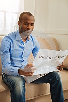 Astonished man reading latest news