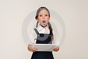 astonished schoolkid with digital tablet looking photo