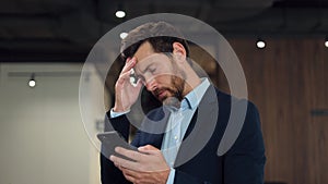 Astonished trader looking at stock exchange market on cellphone and losing money