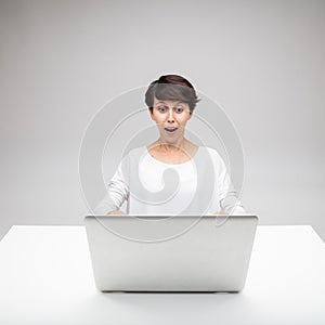 Astonished woman gawping at a laptop