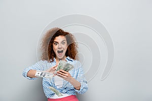 astonished woman screaming while counting dollar