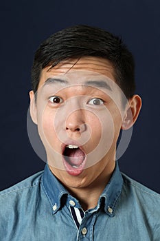 Astonished young Asian man with opened mouth