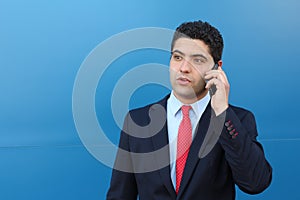 Astonished young businessman on the phone