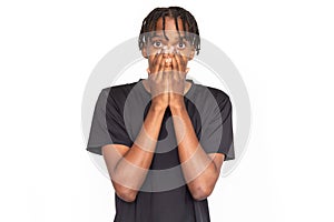 Astonished young man covering his face with hands from shock