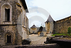 Astonishing landscape view of courtyard with ancient stone buildings in the medieval castle. High stone wall with tower