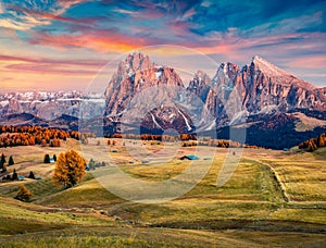 Astonishing sunrise on Alpe di Siusi mountain plateau with Langkofel Sassolungo mountain on background. Beautiful autumn morning