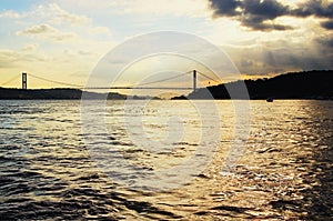 Astonishing sunset landscape view of Bosporus Bosphorus or Strait of Istanbul with black silhouette of bridge in the background