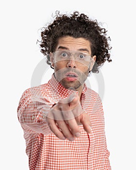 astounded casual man with glasses looking forward and pointing finger photo