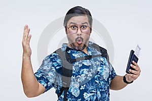 Astounded male tourist in Hawaiian shirt exclaiming ooh while holding a US passport and boarding pass, isolated on a white