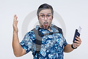 Astounded male tourist in Hawaiian shirt exclaiming ooh while holding a US passport and boarding pass, isolated on a white photo