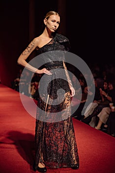 ASTRAKHAN RUSSIA - NOVEMBER 01, 2019. Caspian Fashion Week.A woman model walks the red runway.Fashion show,catwalk event