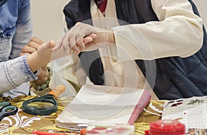 astrologer-palmist conducts a study of the hand of the client and makes a prediction