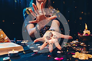 Astrology and esoterism. A sorcerer holds a flaming stones with the sign of the zodiac. Close up. The concept of photo