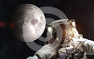 Astronaut on background of Moon. Sun and Earth in reflection of helmet of spacesuit. Elements of the image are furnished by NASA
