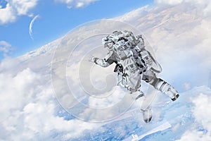Astronaut floating above clouds