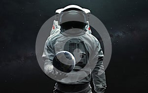 Astronaut holding Earth planet in hand. 3D sci-fi art. Elements of image provided by Nasa