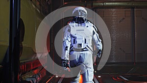 The astronaut leave the control room and walk along the corridor of the interstellar spacecraft. The image is for