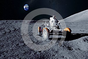 Astronaut near the moon rover on the moon. With land on the horizon. Elements of this image were furnished by NASA