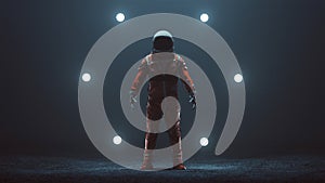Astronaut in an Orange Space Suit with Black Visor Standing in a Alien Void