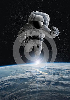 Astronaut in outer open space over the planet Earth.Stars provide the background.erforming a space above planet Earth.Sunrise,