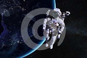 Astronaut in outer space on background of the night Earth.