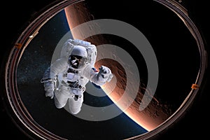 Astronaut in outer space from porthole on background of the Mars. Elements of this image furnished by NASA