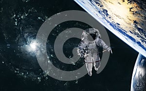 Astronaut, planets on background of spiral galaxy somewhere in deep space