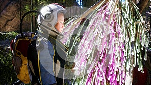 An astronaut-scientist explores an unusual glowing alien plant on an alien planet. Space travel and exploration concept