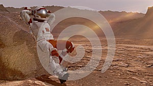 Astronaut sitting on Mars and admiring the scenery. Exploring Mission To Mars. Futuristic Colonization and Space Exploration