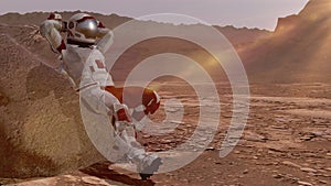 Astronaut sitting on Mars and admiring the scenery. Exploring Mission To Mars. Futuristic Colonization and Space Exploration