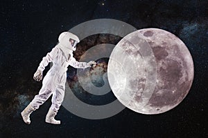 Astronaut in space and moon exploration. Concept, astronaut pulls his hand to the lunar surface