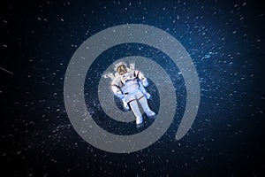 Astronaut spaceman in outer space in full spacesuit on stars sky background