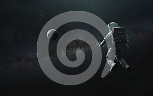 Astronaut at spacewalk looks at Earth planet. Elements of image provided by Nasa