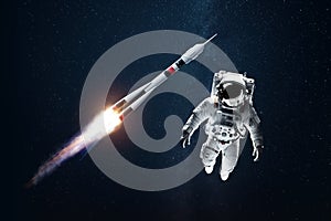 Astronaut in a white spacesuit in space against the backdrop of a rocket. Exploration of space and other planets, colonization of