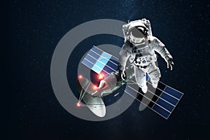 Astronaut in a white spacesuit in space on the background of a satellite. Exploration of space and other planets, colonization of