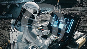 An astronaut works on his laptop at a space base on one of the new planets. 3D Rendering.