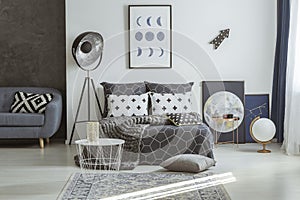 Astronomical posters in grey bedroom interior