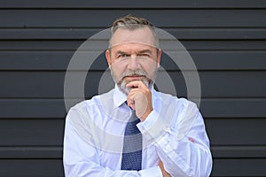 Astute thoughtful businessman staring at the camera