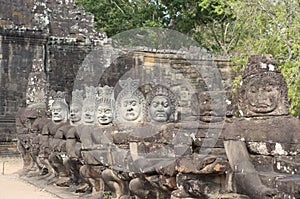 Asuras demons statues in a row at the Bayon Temple entrance gate