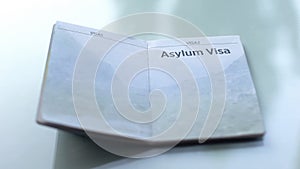 Asylum visa, opened passport lying on table in customs office, travelling
