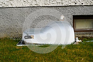 An asymmetrical old bathtub with a seat removed during the renovation, removed from the front of the house to the garden