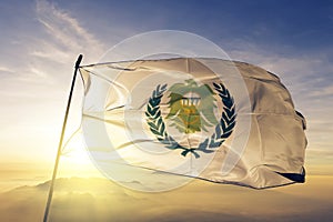 Asyut Governorate of Egypt flag textile cloth fabric waving on the top sunrise mist fog