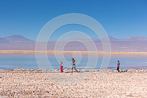 Atacama, Chile - Oct 9th 2017 - Narrow angle shot of parent and a child walking around of the Atacama salar in a fade light , afte