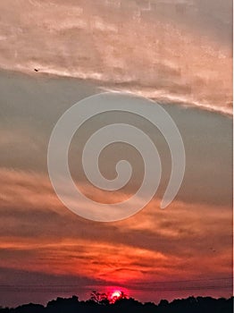 Atardecer en vertical espectacular colores rojos, naranaja, gris, celeste photo