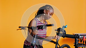 Atelier shop employee setting up bike repair stand to fix busted wheels